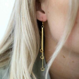 gold hanging stars dangly earrings on model