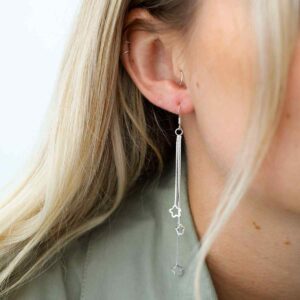 silver hanging stars dangly earrings on model