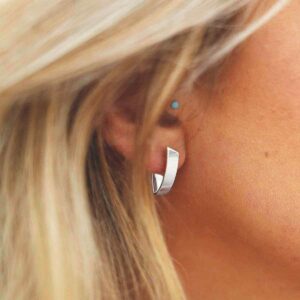 Blonde wearing simple shield studs