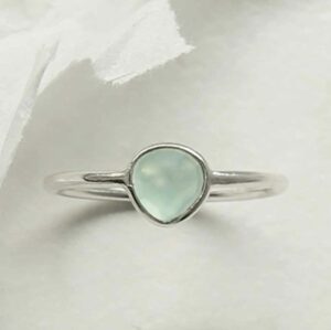 horizontal positioned silver ring with round blue topaz stone