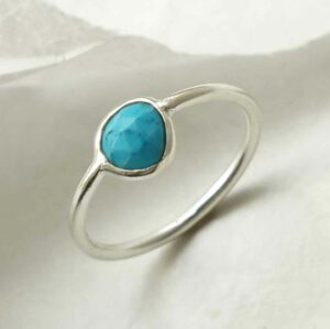 diagonal positioned silver ring with round turquoise stone