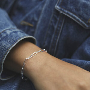 model wearing silver plain paperclip bracelet with denim jacket