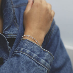 model wearing silver hammered paperclip bracelet with denim jacket