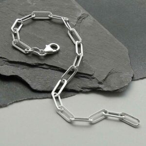 silver flattened link paperclip bracelet strewn on slate