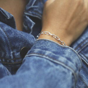 model wearing silver chunky paperclip bracelet with denim jacket