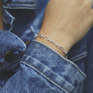 model wearing silver long chunky linked paperclip bracelet with denim jacket