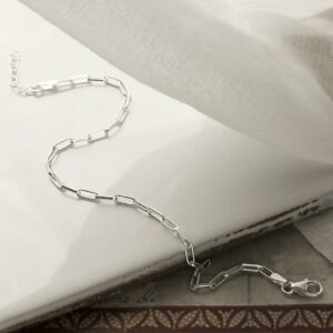 silver thinly linked paperclip bracelet strewn on tile