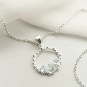 three blue topaz gems in water droplets circle pendant on chain