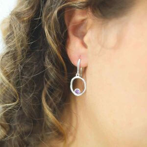 single amethyst gem in oval dangly earrings on model