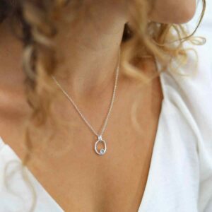 single blue topaz gem in oval pendant on model