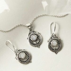 single moonstone gem in decorative earrings and necklace