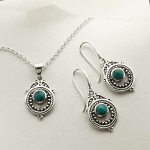 single turquoise gem in decorative earrings and necklace