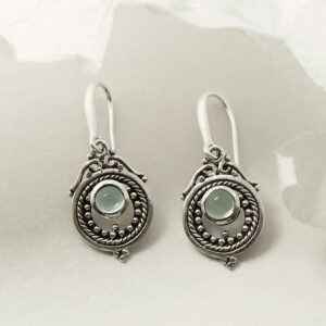 single blue topaz gem in decorative dangly earrings