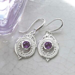 single amethyst gem in decorative dangly shiny earrings