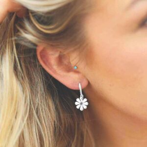 single blue topaz gem in centre of daisy earrings on model