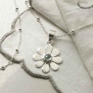 single blue topaz gem in centre of daisy pendant