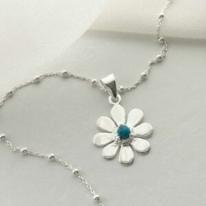 single turquoise gem in centre of daisy pendant