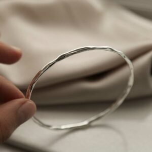 silver rippling thin bangle held on side