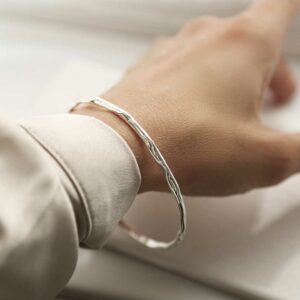 silver rippling thin bangle worn on wrist