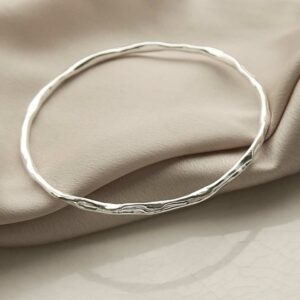 silver rippling thin bangle on linen