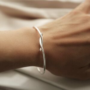 silver entwined bangle worn on wrist