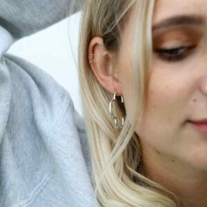 Blonde Model In Grey Jumper wearing Sterling Silver Flower Hoops