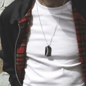 meteorite and carbon fibre curve dog tag necklace on stretching male model