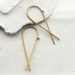 gold wire loop with ball earrings strewn on stone