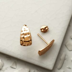 rose gold hammered triangle studs taken apart on tile