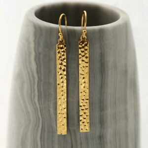 gold dangly straight earrings hanging out a pot