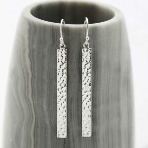 Silver dangly straight earrings hanging out a pot