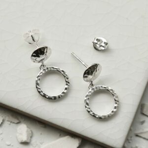 a pair of silver circle stud earrings on a white tile