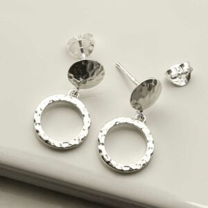 a pair of silver circle stud earrings on a white tile