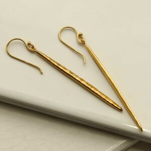 Gold Icicle Dangly Earrings on tile background