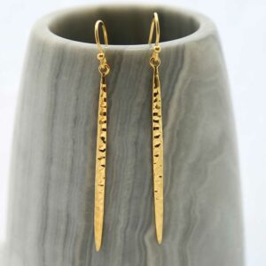 Gold Icicle Dangly Earrings hanging on grey prop