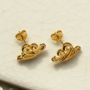 Gold Wave Studs on white tile background