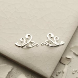 Silver Wave Studs on white tile background