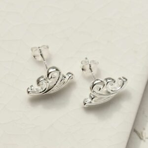 Silver Wave Studs on white tile background