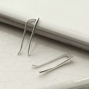 Curve Threader Climber earring on white tile background