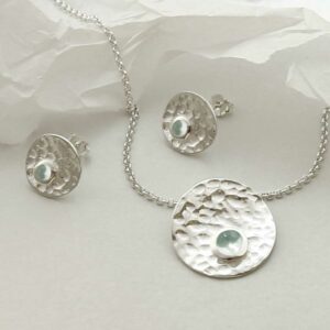 single blue topaz gems in centre of hammered necklace and earrings