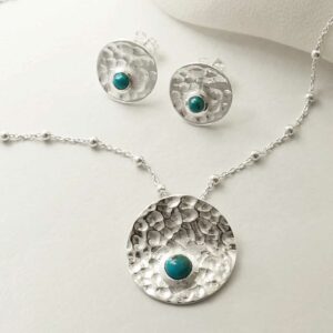 single turquoise gems in centre of hammered necklace and earrings