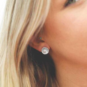 single moonstone gem in centre of hammered stud earrings on model