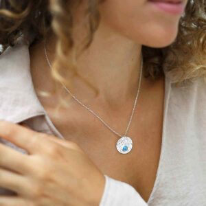 single opalite gem in centre of hammered pendant on model