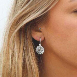 single blue topaz gem in centre of chrysanthemum earrings on model