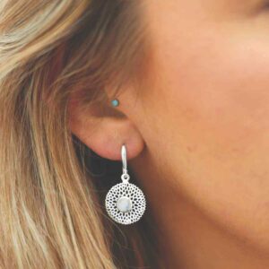 single moonstone gem in centre of chrysanthemum earrings on model