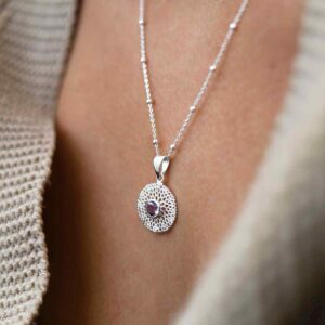 single amethyst gem in centre of chrysanthemum pendant on model