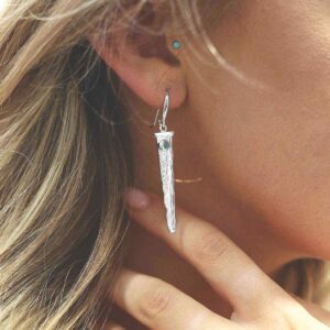 silver water pour earrings with blue topaz on model