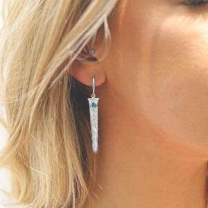 silver water pour earrings with turquoise on model