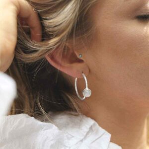 silver textured stud hoops with moonstone on model