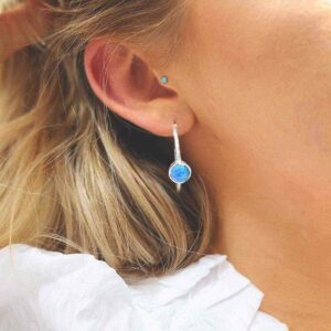 silver textured stud hoops with opalite on model